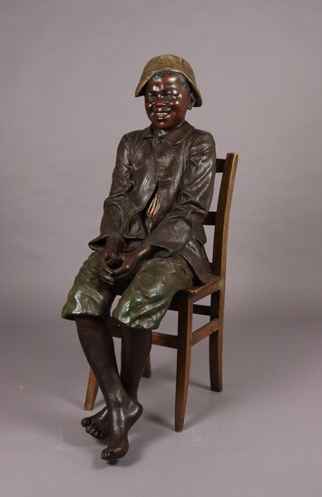 Seated boy by Goldscheider